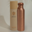 Eine Copper Specialist Wasserflasche aus reinem Kupfer mit einem Blume des Lebens Symbol, neben ihrer zylindrischen Verpackung.