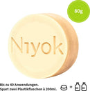 Rundes, hellgelbes festes Duschstück mit Niyok-Logo und 80g-Aufkleber.