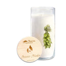 Eine hohe weiße Kerze in einem mit Blumenmuster verzierten Glashalter, neben einem runden Holzdeckel mit der Aufschrift „Innerer Frieden“.